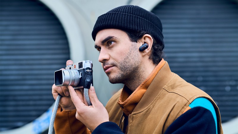 Man wearing hearables with smart sensors by Bosch Sensortec and taking pictures in Berlin